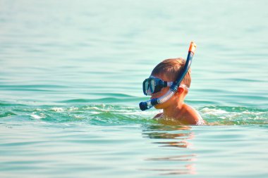 Denizdeki deniz tüplü çocuk. Denizde tüplü dalış. Okyanustaki gözlüklü çocuk.