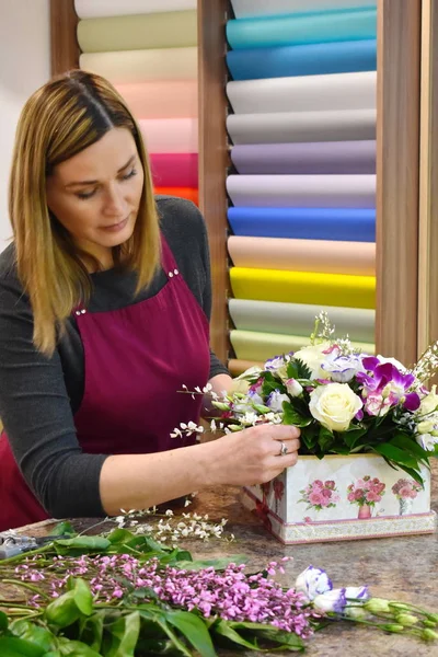 The woman in the flower shop. Florist at work. Florist making a floral arrangement. Girl with flowers