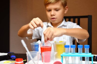 Meraklı bir öğrenci. Evde eğitim. Evde fiziksel deneyler. Çocuk kimya ile meşgul.