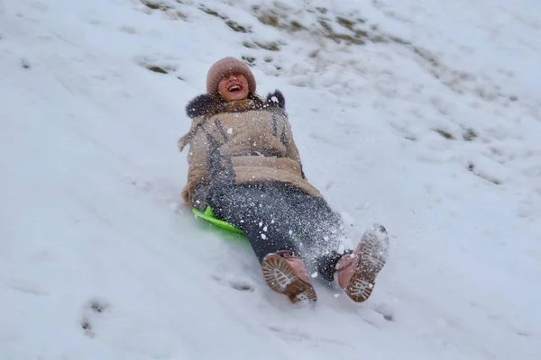 Mädchen in einem Karton auf einem Hügel im Winter. Kind, um im Winter Spaß zu haben. Winter ist lustiges Spiel. Sportliche Feiertage zu Weihnachten. — Stockfoto