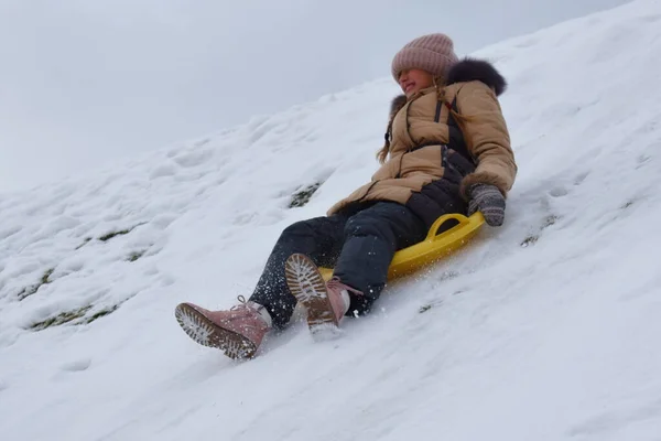 Mädchen in einem Karton auf einem Hügel im Winter. Kind, um im Winter Spaß zu haben. Winter ist lustiges Spiel. Sportliche Feiertage zu Weihnachten. — Stockfoto