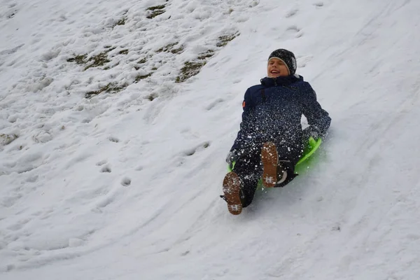 Il ragazzo sta andando a Box Hill. Allegre vacanze invernali. Ragazzo a cavallo di una collina di neve — Foto Stock