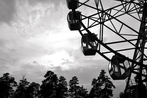 Monochrome photo. Big wheel in the city park at sunset. Rest in the amusement park — Stock Photo, Image