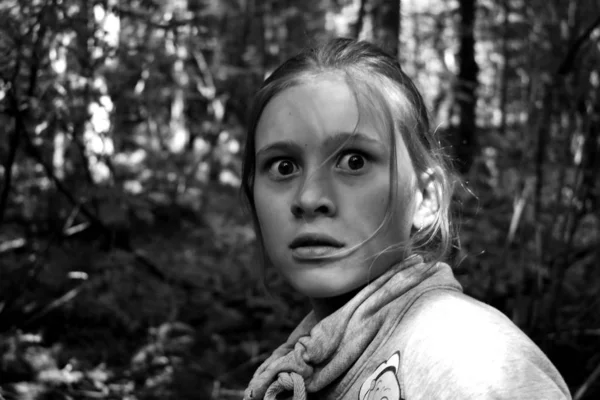 Monokróm fotó. Félelmetes pillantás a lányra. Egyes gyerek az erdőben fél. — Stock Fotó