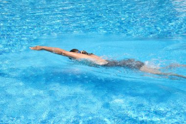 Female swimmer in pool. swimming training. Swimming in the outdoor pool. A healthy lifestyle at the resort.