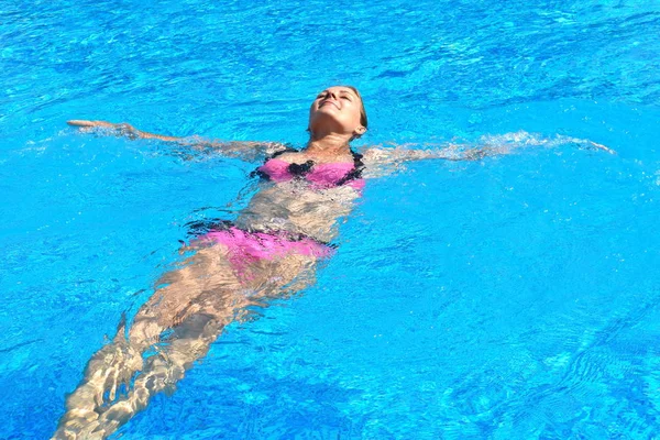Retrato de uma rapariga na piscina. Uma mulher nada na piscina. Férias de verão no verão na água. Spa férias . — Fotografia de Stock