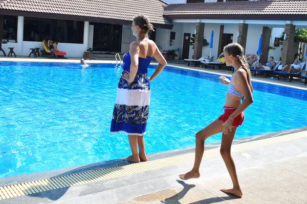 Umas férias em família cheias de diversão. Atirar a mulher para a água. A criança empurrou os pais para a piscina. Cair na água . — Fotografia de Stock