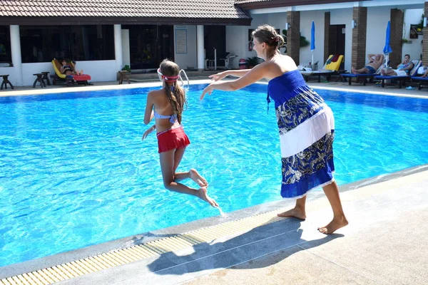 Mother and daughter having fun by the pool. Happy parenthood. The mother and daughter at a hotel in the tropics — 스톡 사진