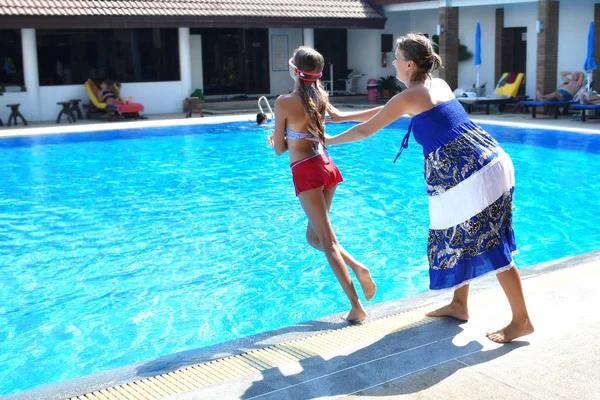 Mother and daughter having fun by the pool. Happy parenthood. The mother and daughter at a hotel in the tropics — 스톡 사진
