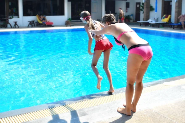 Mother and daughter having fun by the pool. Happy parenthood. The mother and daughter at a hotel in the tropics — 스톡 사진