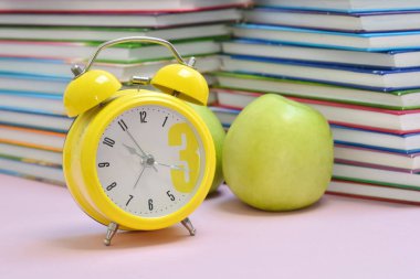 Okul kitapları ve yeşil elmalar. Öğrencinin sağlıklı bir kahvaltısı. Eğitim ve yemek..