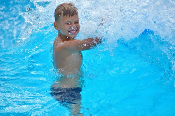 Menino numa prancha de água. Fique no parque aquático no verão . — Fotografia de Stock