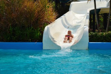 Happy child in the water Park. Girl in the pool in the summer autdoor.
