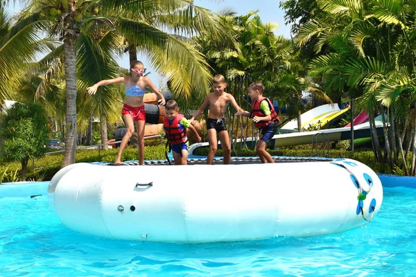 Children in the outdoor pool. Funny kids at the water Park. Happy summer vacation — Stock Photo, Image