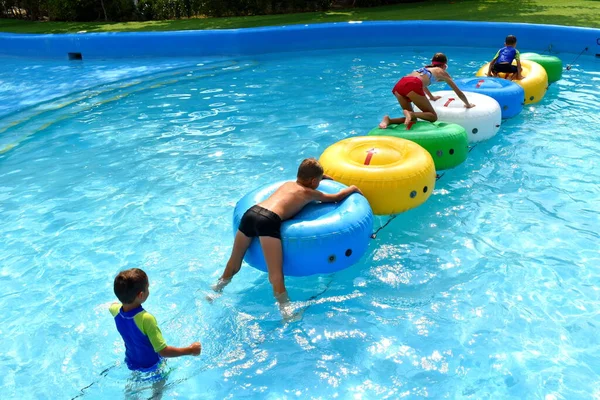 Children in the outdoor pool. Funny kids at the water Park. Happy summer vacation — Stock Photo, Image