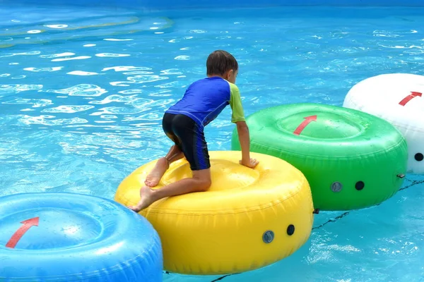 El chico en la piscina en el autdoor de verano. Vacaciones en el parque acuático. Alegre verano en el agua —  Fotos de Stock