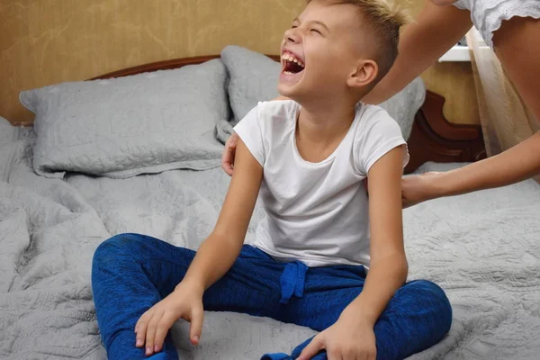 Faz cócegas à criança. Mãe e filho felizes na cama. Mãe engraçada . — Fotografia de Stock