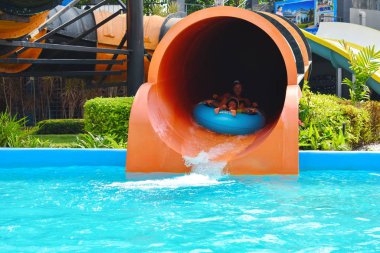 Fun descent with a water slide. Happy people in the Park
