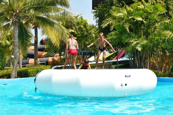 a water trampoline in the water Park. Funny kids on inflatable trampoline.