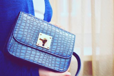 Little women's blue bag. fashion lady with a handbag in the window