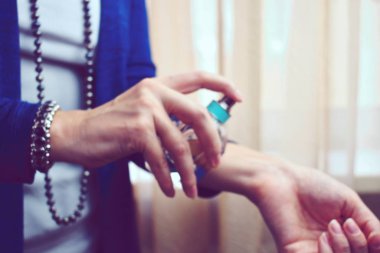 Stylish girl Squirting perfume on the wrist. to meet a date. Gift on March 8.