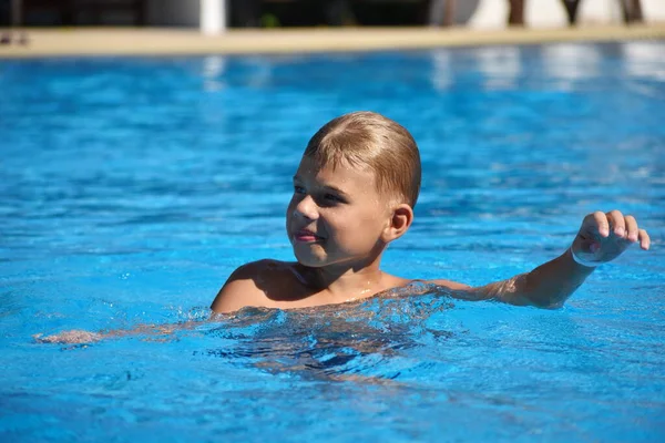 Child boy swimmer. The boy in the pool at the hotel. Sports holiday with children at the resort. — 图库照片