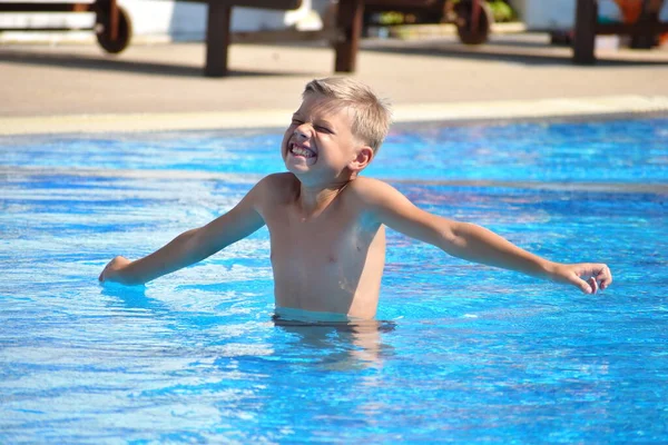 Menino nadador. O rapaz na piscina do hotel. Férias desportivas com crianças no resort . — Fotografia de Stock