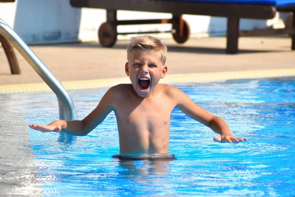 Child boy swimmer. The boy in the pool at the hotel. Sports holiday with children at the resort. — Stock fotografie