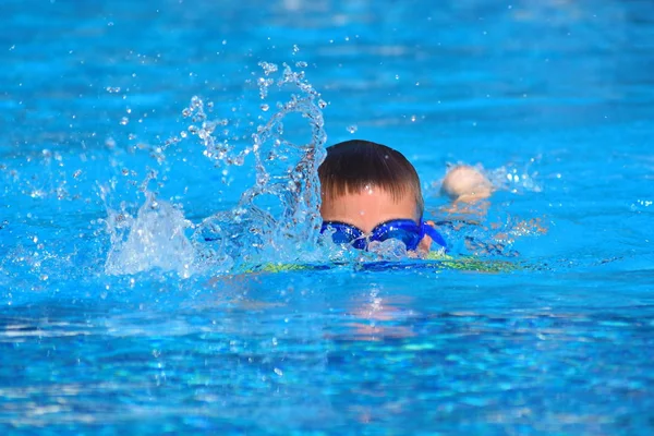 Niños bajo el agua vasos en la piscina autdoor. El niño aprende a nadar en la piscina . — Foto de Stock