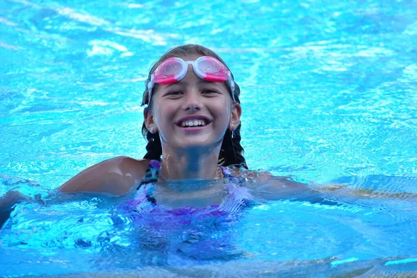 Niña nadadora en la piscina. Sporting vacaciones de verano saludables con los niños . — Foto de Stock