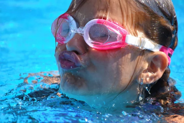 小女孩在游泳池里游泳。与孩子们一起度过一个健康的暑假. — 图库照片