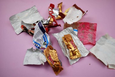 Empty candy wrappers on the table. Eating a lot of sweets