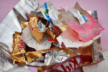 Empty candy wrappers on the table. Eating a lot of sweets clipart