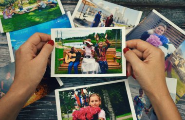 Elinde fotoğraf tutan bir kadın. Aile fotoğrafları ayarlanıyor. Aile fotoğrafı albümünü izle.