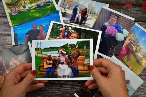 Female hand holding a photograph. Setting family photos. Watch family photo album. — Stock Photo, Image