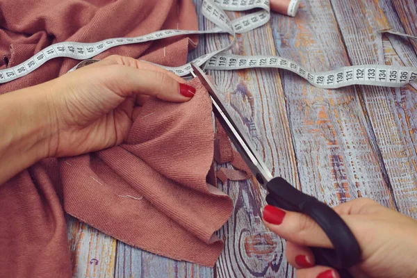 Woman seamstress sews clothes. The fabric on the table. Women\'s needlework.