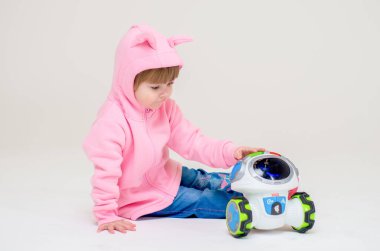 Gri arka planda bir kız bebek. Stüdyoda oyuncak ile şirin bir bebek.