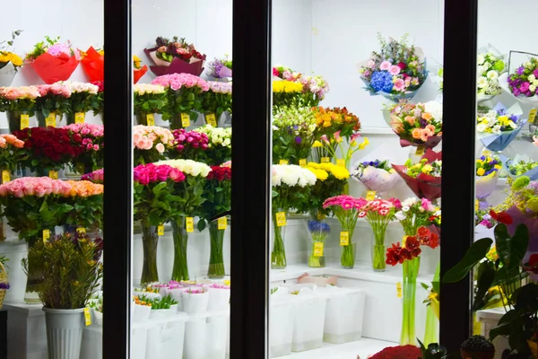 花と冷蔵庫付きのインテリア。花屋の花瓶にバラ. — ストック写真