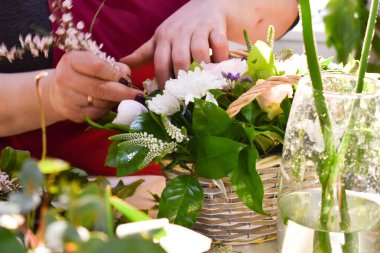Bir kadın taze buket yapar. Çiçekçi çiçek aranjmanı topluyor. Çiçekçide satıcı..