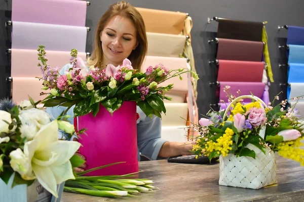 Жінка робить свіжий букет. Флорист збирає квіткові композиції. Продавець у квітковому магазині . — стокове фото