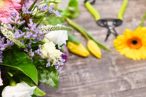 Bukiety kwiatowe na stole. Kwiatowe tło. Narzędzia kwiaciarni. — Zdjęcie stockowe