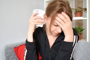 Kadın baş ağrısından muzdarip. Kronik migren. Ağrı kesici.