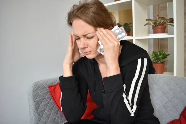 La mujer sufre de dolor de cabeza. Migraña crónica. Pastillas para el dolor — Foto de Stock