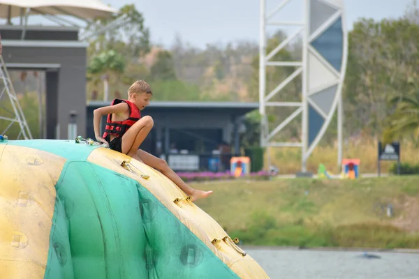 Jongen water opblaasbare glijbaan. Sport wateractiviteiten voor kinderen. — Stockfoto
