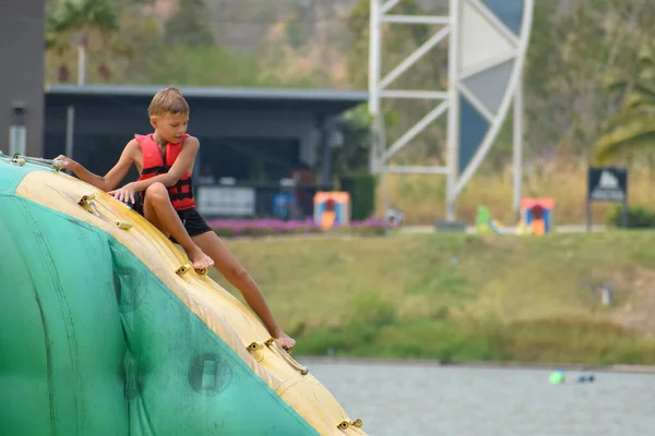 Boy child water inflatable slide. Sports water activities for kids. — Stock Photo, Image