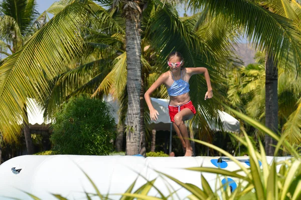 Dziewczyna w stroju kąpielowym skacze do wody w basenie. — Zdjęcie stockowe