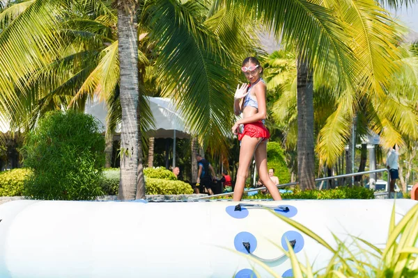 Meisje in een badpak springt in het water in het zwembad. — Stockfoto