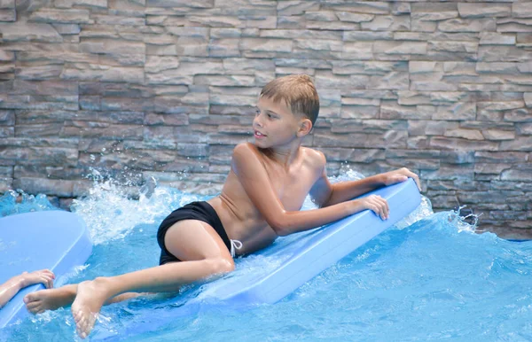 Der Junge im Wasser. Ein Kind schwimmt im Sommer auf den Wellen — Stockfoto