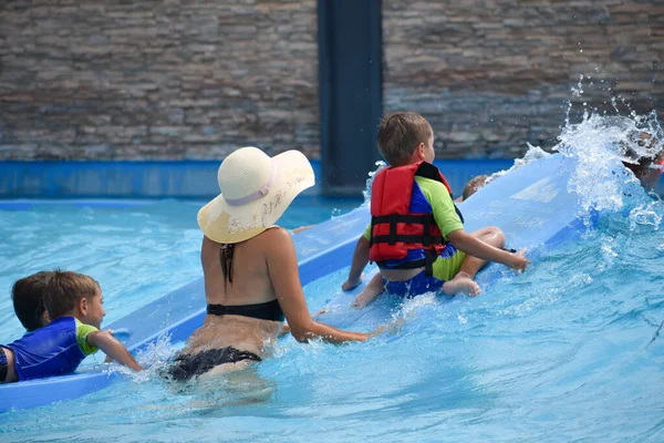 Děti v létě v aquaparku. Zábavná aktivní dovolená ve vodě — Stock fotografie
