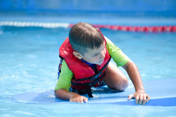 Ação segura na piscina. Casaco de vida no menino. Salvando a criança da água — Fotografia de Stock
